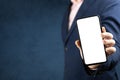 Mockup phone. Businessman shows cell phone with blank screen. man in suit hold mobile phone with blank white screen on dark blue Royalty Free Stock Photo