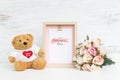 Mockup Picture frame and cute bear with Bouquet of pink roses on grunge white wood. Valentines Day Background concept with copy Royalty Free Stock Photo