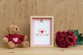 Mockup Picture frame and cute bear with Bouquet of red roses on rusty wood. Valentines Day Background concept with copy space. Royalty Free Stock Photo