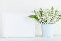 Mockup of picture frame decorated flowers in vase on white background with clean space for text. Royalty Free Stock Photo