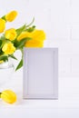 Mockup of picture frame decorated yellow tulip flowers in vase on white background with clean space for text Royalty Free Stock Photo