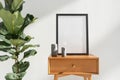 Mockup picture frame near houseplant on side table with drawer Royalty Free Stock Photo