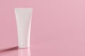 Mockup Plastic white tube for cream or lotion. Skin care cosmetic in top view on pink background. Beauty concept for face care. Royalty Free Stock Photo