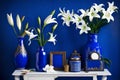 Mockup poster frame cozy royal blue interior background with white Lilly jar Royalty Free Stock Photo