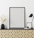 Mockup poster frame in modern interior with white wall, table lamp, calendar and golden print chest of drawers, home office