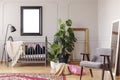 Mockup poster in grey baby room interior with green plants and retro armchair,