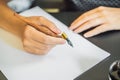 MOCKUP, SCENE CREATOR Calligrapher Young Woman writes phrase on white paper. Inscribing ornamental decorated letters