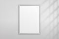 Mockup silver frame photo on wall. Mock up picture framed. Vertical modern boarder with shadow. Empty photoframe a4 isolated on ba