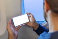 Mockup smartphone airplane. Young attractive european man holding blank screen smartphone in hands in airplane. Mock up for a game