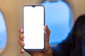 Mockup smartphone airplane. Young attractive european man holding blank screen smartphone in hands in airplane. Mock up for a game