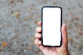 Mockup smartphone in male hand. Blank white touchscreen held by the adult male outdoor. Technology and communication concept