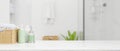 Mockup space on tabletop with shampoo bottles, wicker basket over modern white bathroom