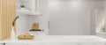 Mockup space on white kitchen tabletop over blurred white kitchen interior Royalty Free Stock Photo