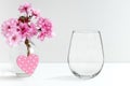 Mockup - stemless wine glass, next to blossom in a vase Royalty Free Stock Photo