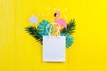 Mockup Summer tropical leavess with flamingo bird on yellow wooden background. Jungle palm and monstera leaves with