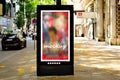 sample lightbox ad panel along sidewalk. bus shelter advertising. blurred urban background Royalty Free Stock Photo