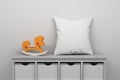 Mockup template with little toy hourse and white blank pillow displayed on sitting cabinet