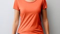 Mockup template of woman in orange t shirt for design print studio on light gray wall