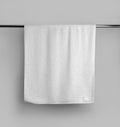 Mockup of a terry white towel with a label on a metal bar, hanging towelling for design, branding