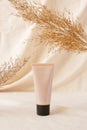 Mockup tonal CC or BB cream foundation makeup tube mockup on linen drapery and dry plant. Concept eco organic cosmetic