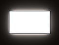 MockUp of TV or Ad Screen with Backlight in the Dark on the Wall Royalty Free Stock Photo