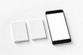 Mockup of two blank vertical business cards and black cell-phone at white textured paper Royalty Free Stock Photo