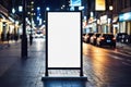 Mockup, vertical advertising banner billboard stand, blank white canvas, positioned on a sidewalk during night, surrounded by city Royalty Free Stock Photo