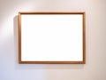 Empty single vintage brown rectangular simple photo frame hanging on white wall background with warm light. Royalty Free Stock Photo