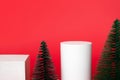 Mockup white cube podiums and Christmas decoration fir tree on red background Royalty Free Stock Photo