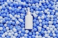 Mockup white dropper bottle with serum for cosmetics products or advertising lies on blue balls or spheres, 3d abstract render Royalty Free Stock Photo