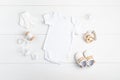 Mockup of white infant bodysuit made of organic cotton with eco friendly baby accessories