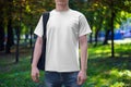 Mockup of a white men\'s T-shirt with a round neck, shirt on a guy with a backpack, front view Royalty Free Stock Photo