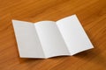 Mockup of white opened three fold brochure business on wooden