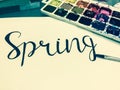 Mockup with a White Page, Word Spring, Paints and Brushes