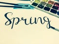 Mockup with a White Page, Word Spring, Paints and Brushes