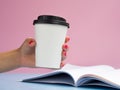 Mockup white paper coffee cup to go with a opened magazine. Side view on blue background. Copy Space for text Royalty Free Stock Photo