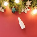 Mockup of white plastic spray bottle, Christmas fir tree and Christmas decorations on red background. Top view, flatlay style Royalty Free Stock Photo