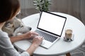 Mockup white screen laptop woman with a pet dog using computer while sitting at table at home, back view Royalty Free Stock Photo