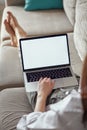 Mockup white screen laptop woman using computer lying on sofa at home, back view, focus on screen Royalty Free Stock Photo