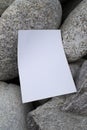 Mockup of white A4 sheet on large gray stones of mountain rivers with space for text or design