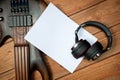 Mockup with a white sheet of paper with a guitar and headphones for music themes and drawings