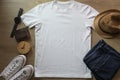 Mockup of a white t-shirt blank shirt template with accessories on the wooden table background, lifestyle and travel concept