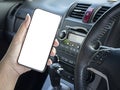 Mockup of woman driver hand using blank white screen mobile smart phone inside a car Royalty Free Stock Photo