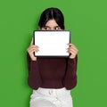 Mockup of a woman holding a blank screen tablet while slightly covering her face Royalty Free Stock Photo