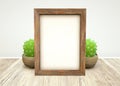 Mockup of wooden frame and green succulent plant in ceramic pot on wooden table Royalty Free Stock Photo