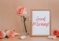 Mockup Wooden frame with text good morning on blank and delicate pink roses on beige background. Minimal trendy