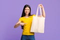 Mockup For Your Design. Joyful Asian Girl Pointing At Blank Tote Bag