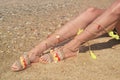 Model advertises bohemian greek sandals at the beach