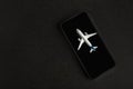 Model airplane on smartphone, black background. Application for searching airtickets Royalty Free Stock Photo