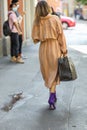 September 24, 2020: model wears a pair of purple heeled ankle boots and a brown overcoat